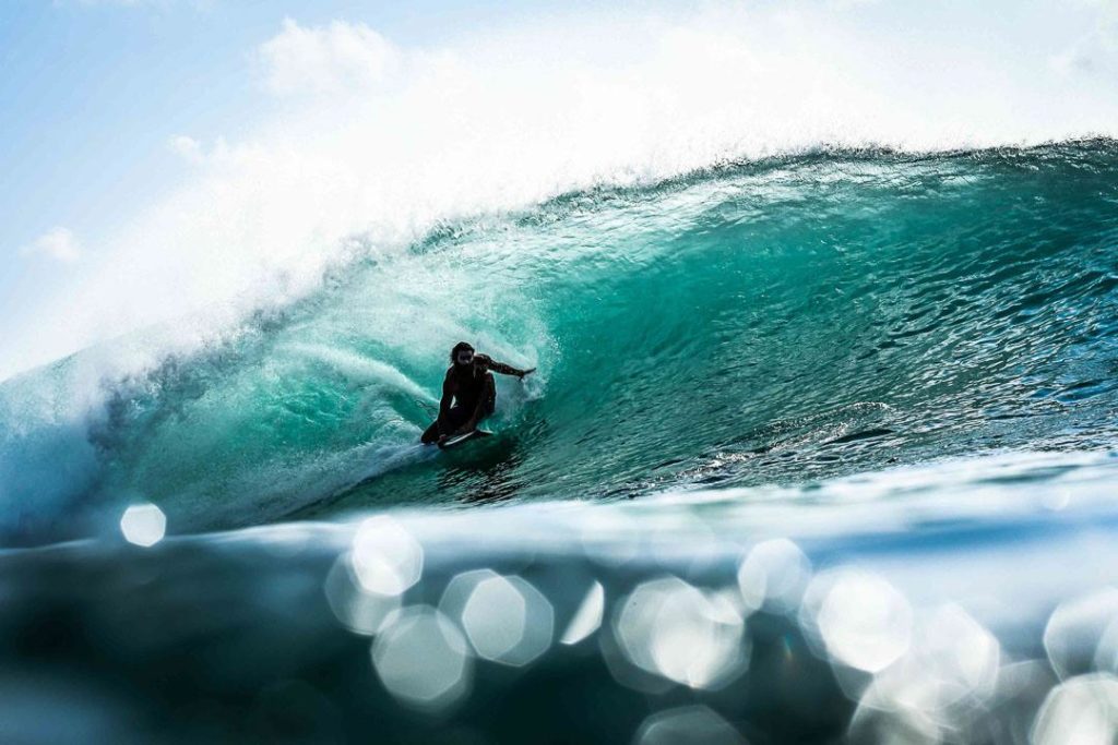 A surfer in Bali riding a barrel wave tube