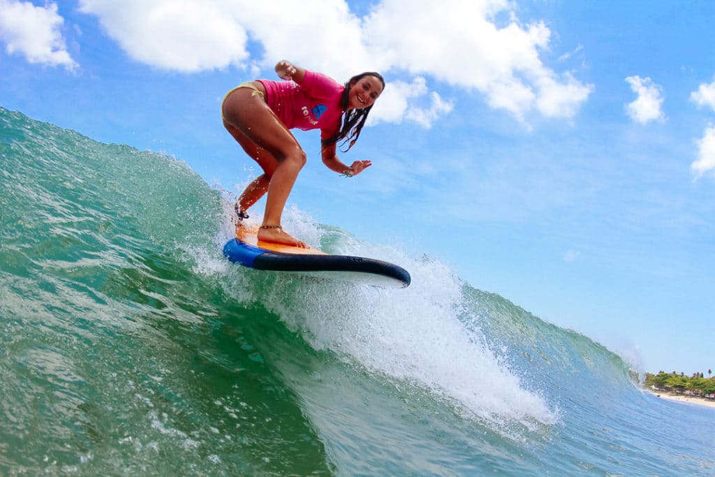 A beginner surfer girl catching a wave in Bali