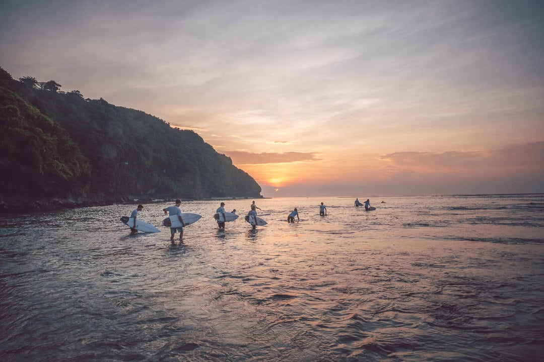 A group of surfers in the sunset on Bali Padang beach