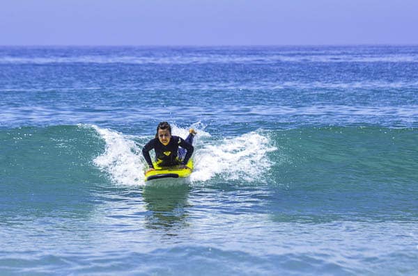 Girl popping up on a surfboard