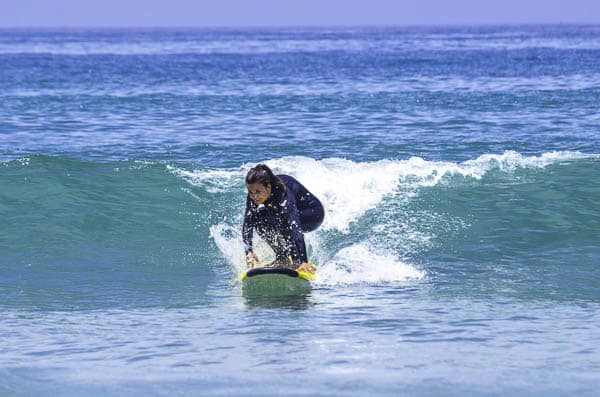 Girl popping up on a surfboard