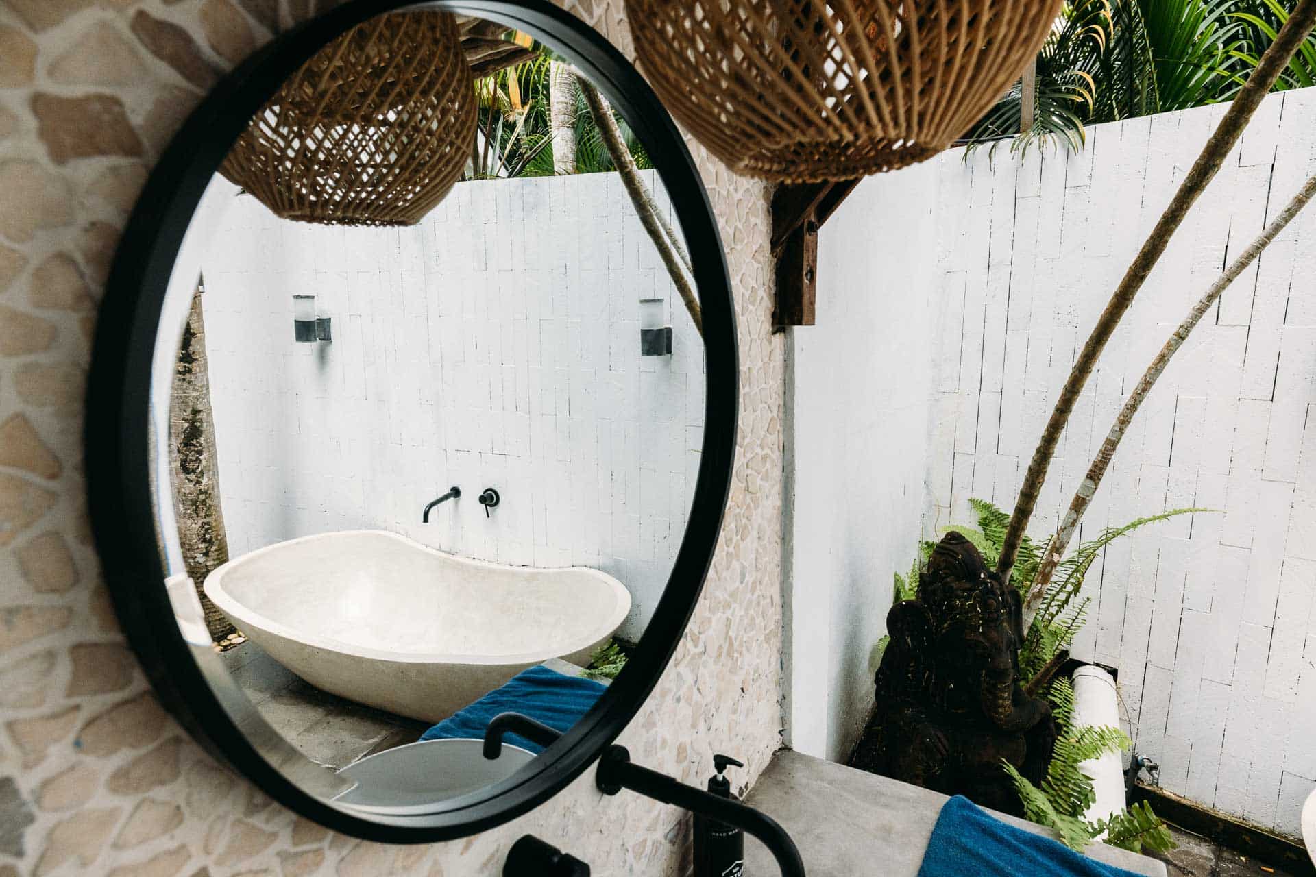 An outside bathroom with bathtub view in mirror