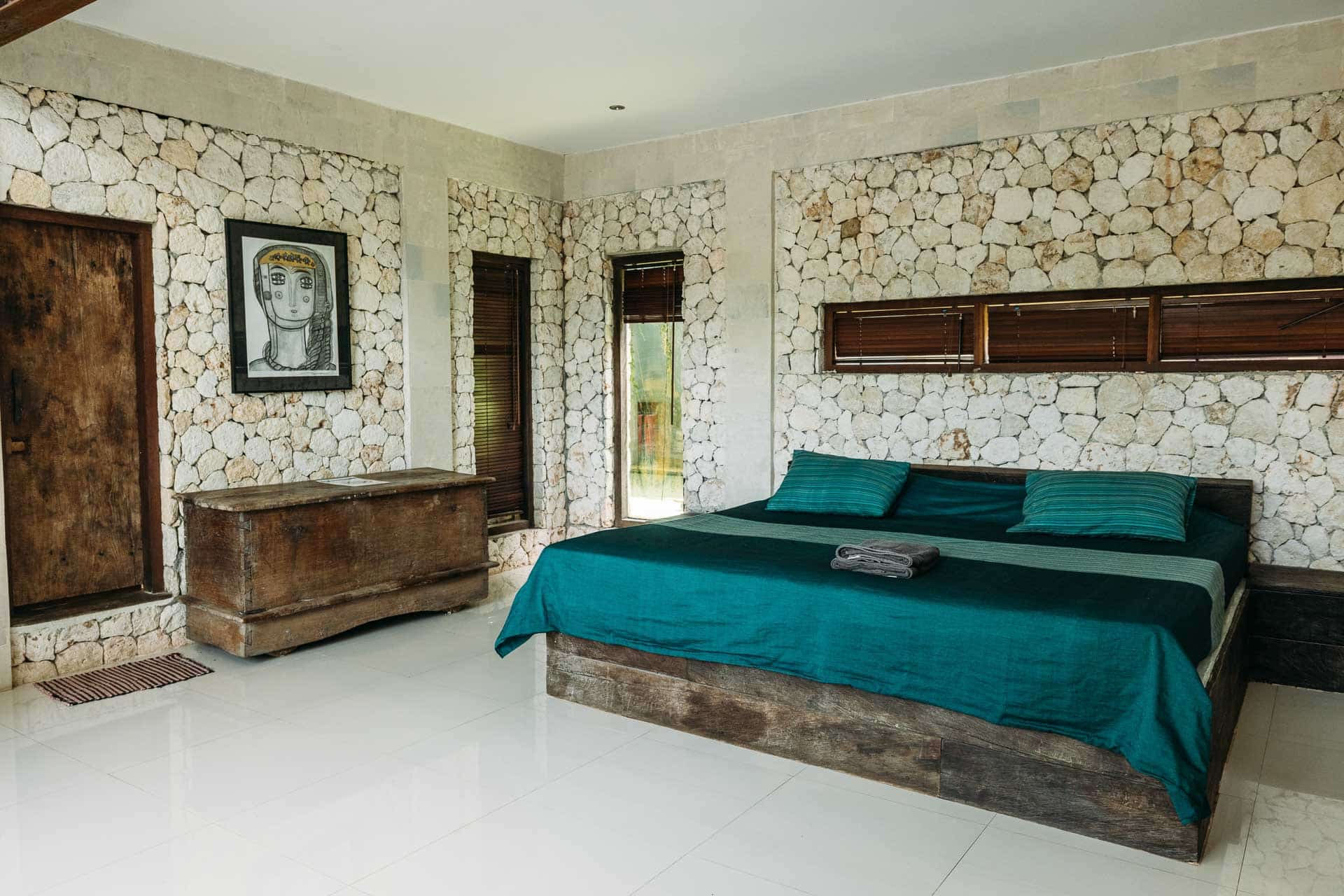 A room in hotel with stones for walls and a king-size bed with rustic decor