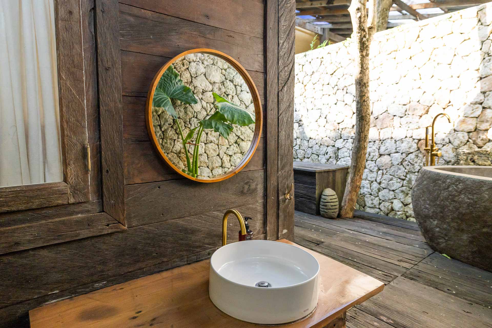An outside bathroom decorated with earth tones and island vibes