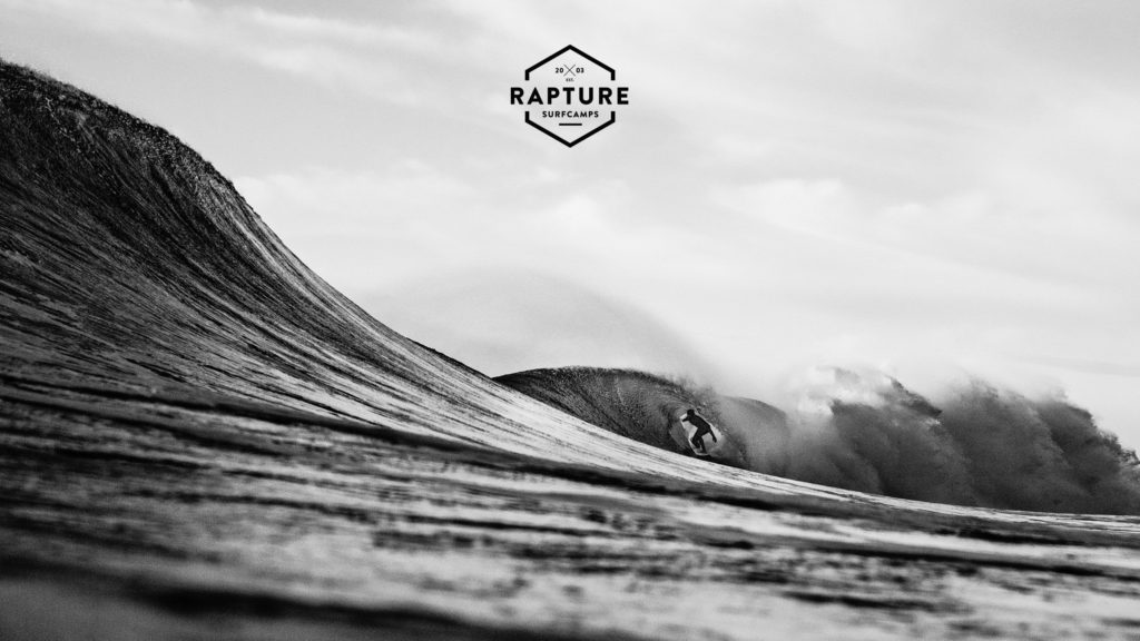 A surfer on barrel wave in black and white