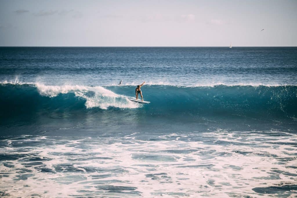 Mann, der Welle in Boardshorts surft