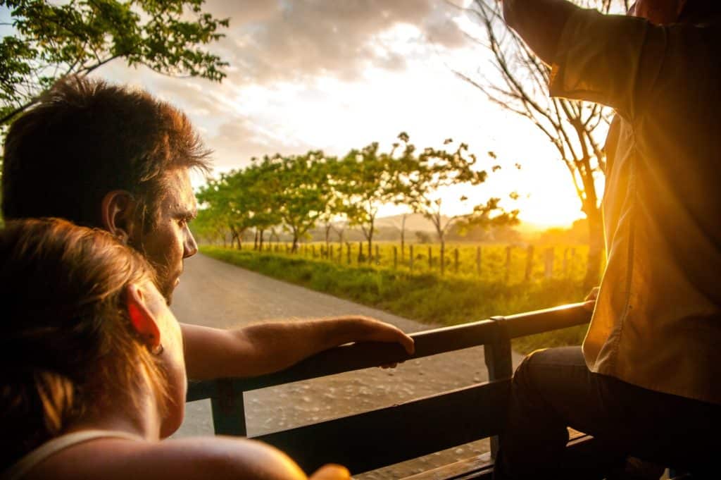 Paar, das den Sonnenuntergang von Costa Rica von der Rückseite des Lastwagens genießt