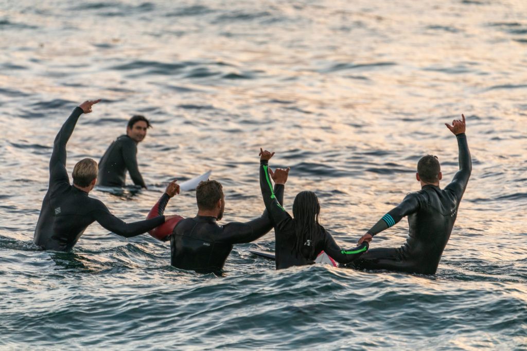 Surfers die sich gegenseitig im Wasser unterstützen
