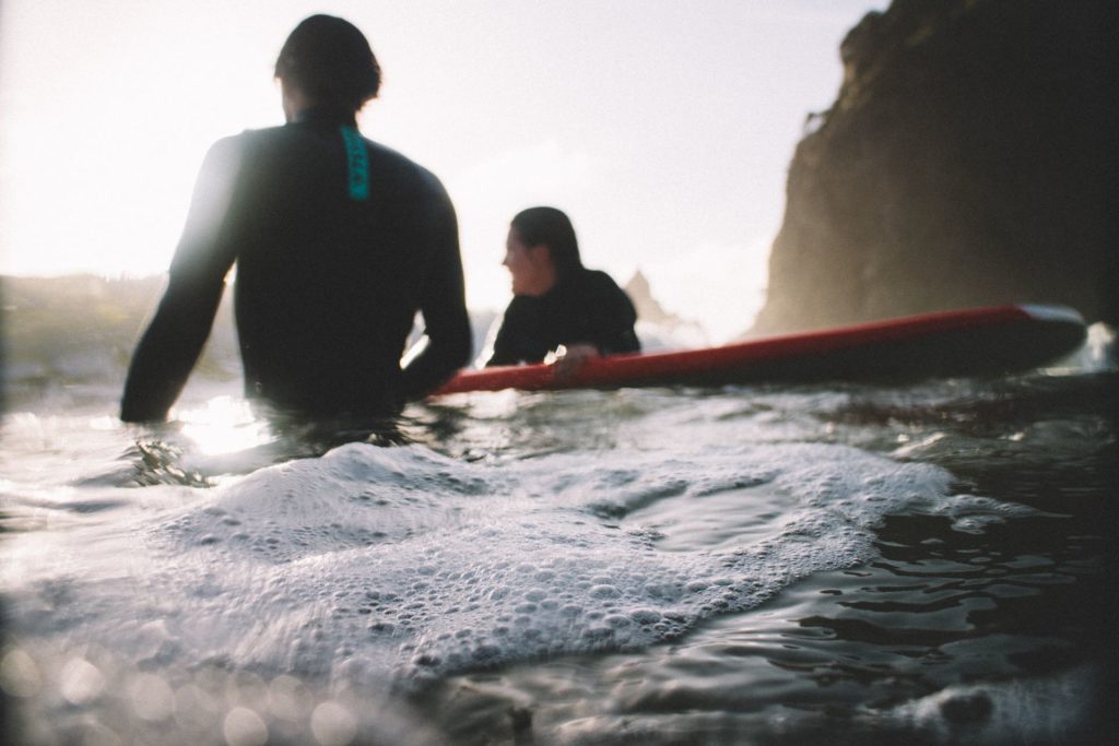 A surf instructor helping a beginner surfer