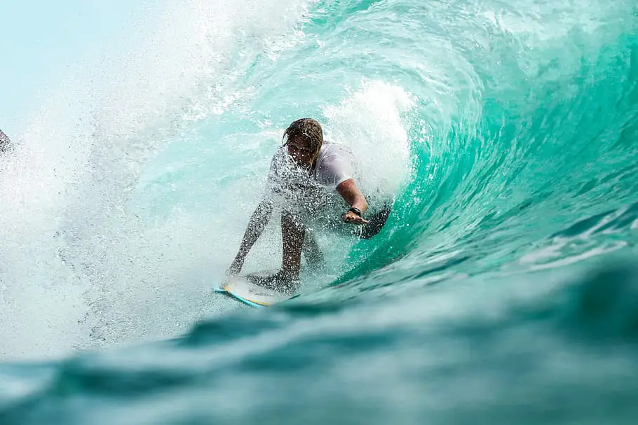 surfer pulling into the barrel of a wave