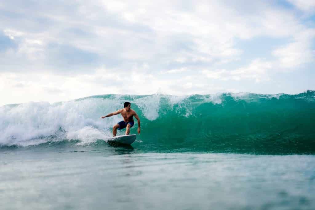 Mann, der auf Bali über eine Welle surft