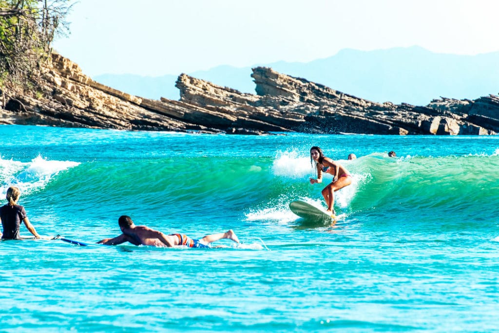 Beginner surfer girl cathing wave