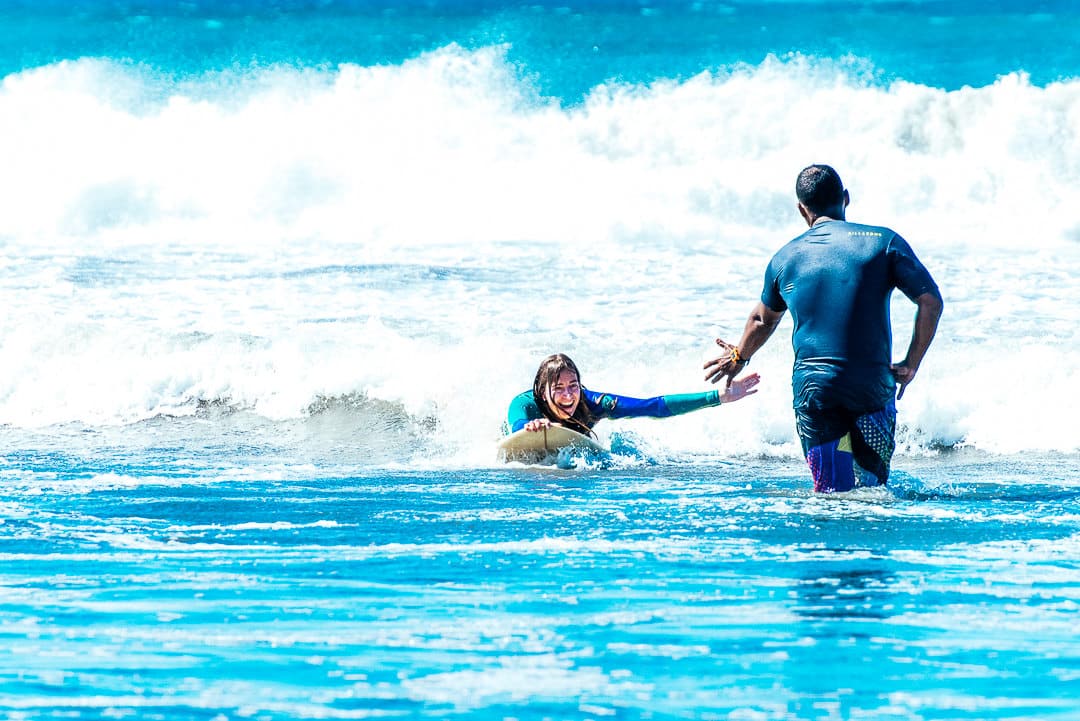 Surfer and instructor high five