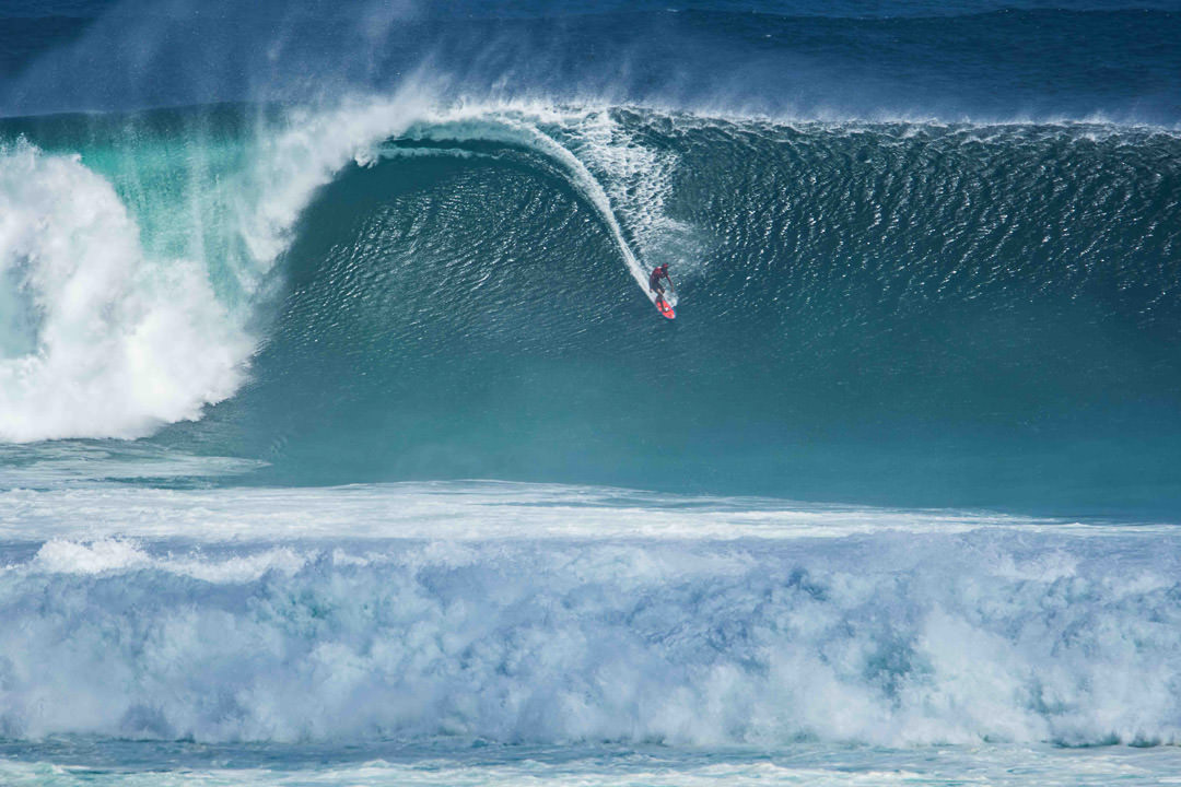 Surfer riding a massive wave in Bali