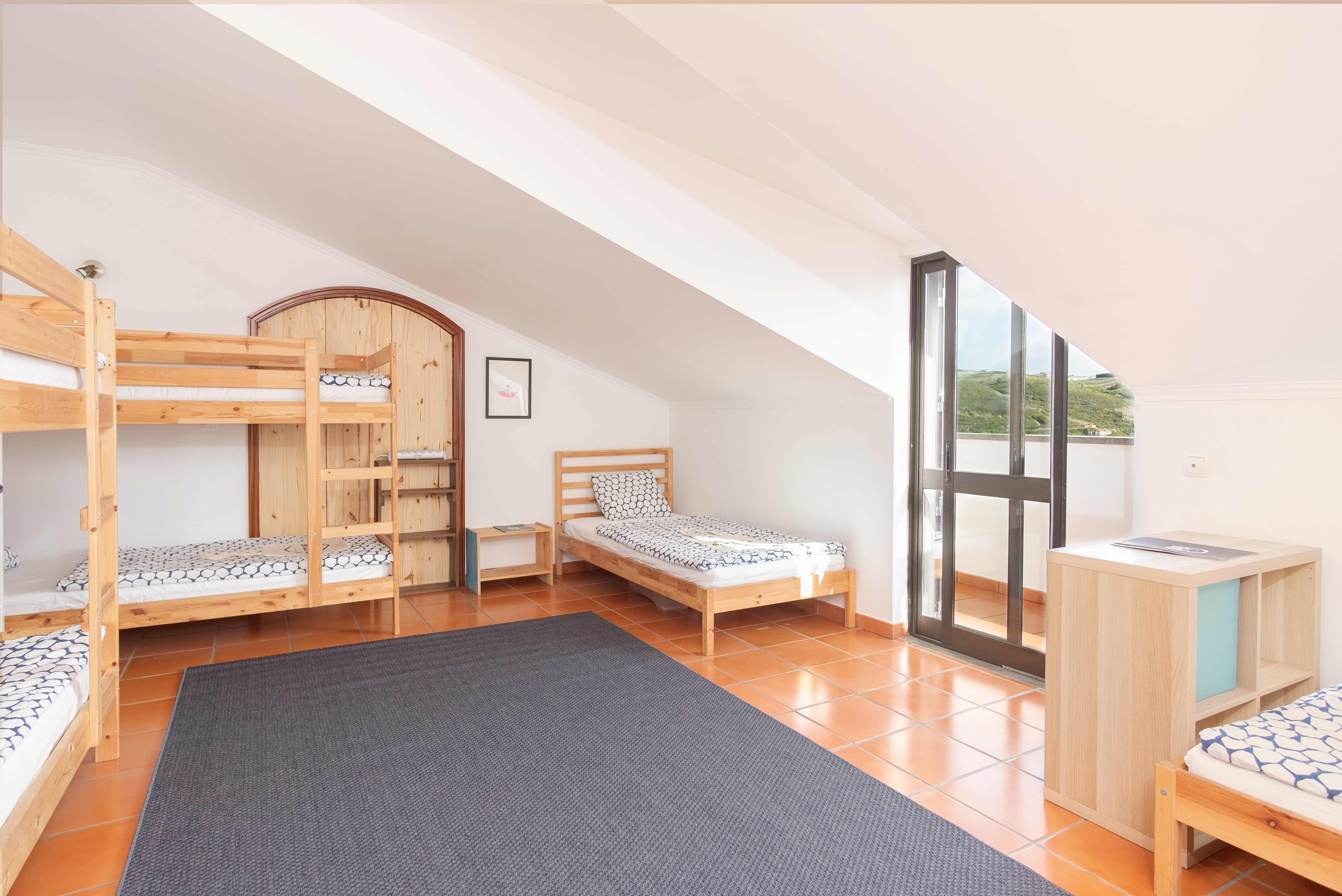 Betten und Fenster im Standard-Mehrbettzimmer Ericeira Rapturecamps