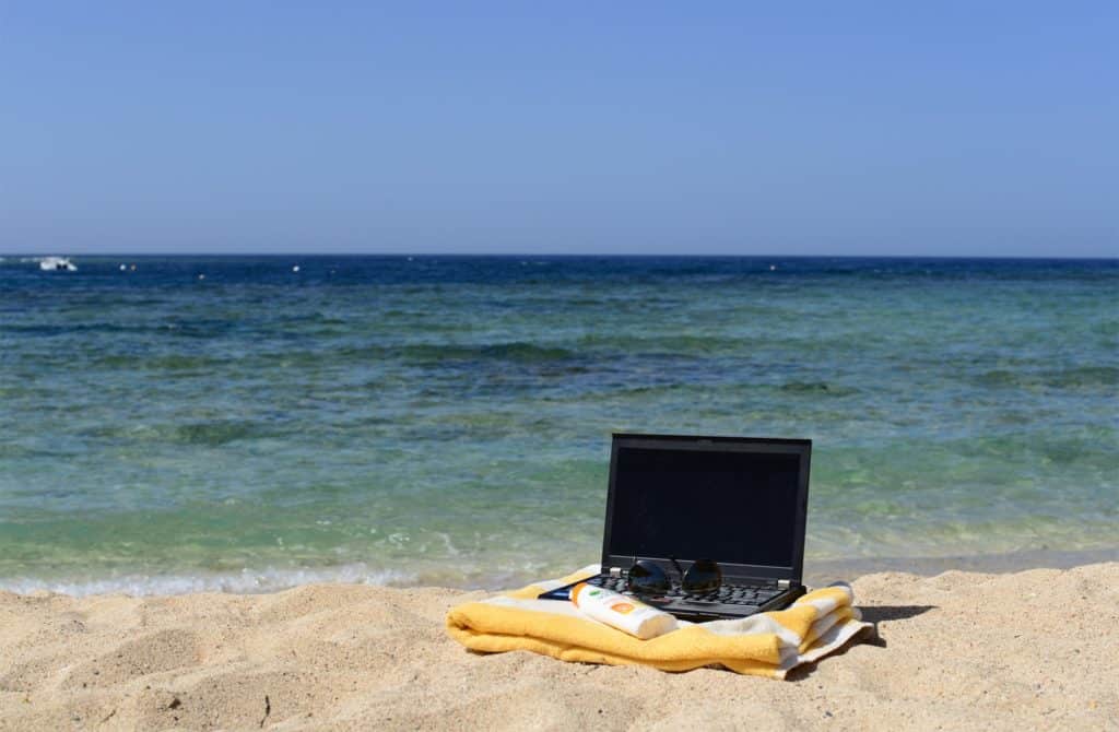 Laptop am Strand Digitaler Nomade im Surfcamp
