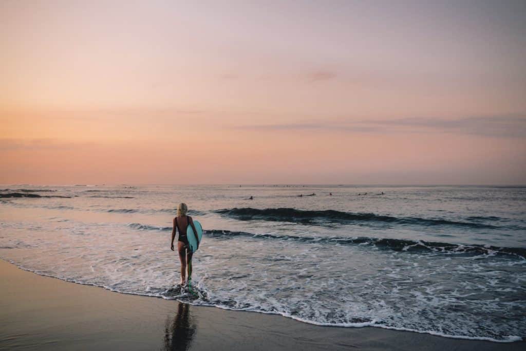 Female surfer walking down the beach