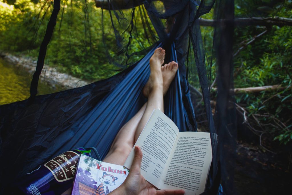 Girl reading a book in a hammock