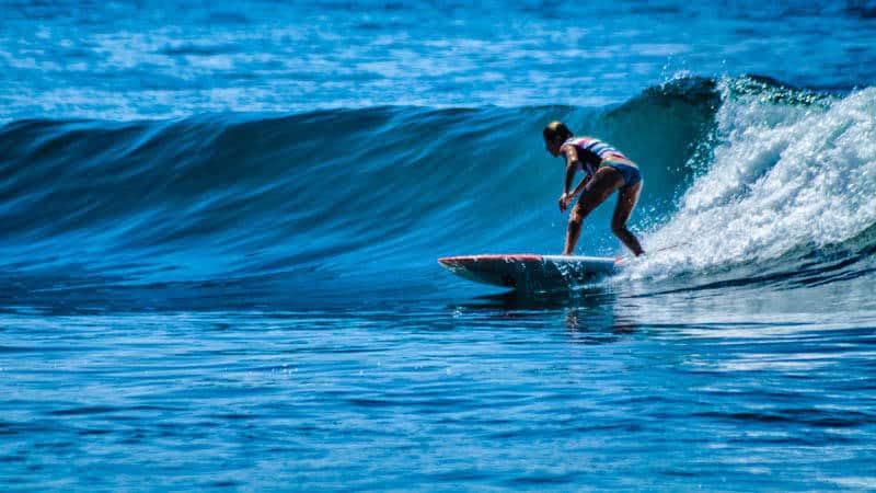 Girl surfing across a wave at our surf camp in Costa Rica
