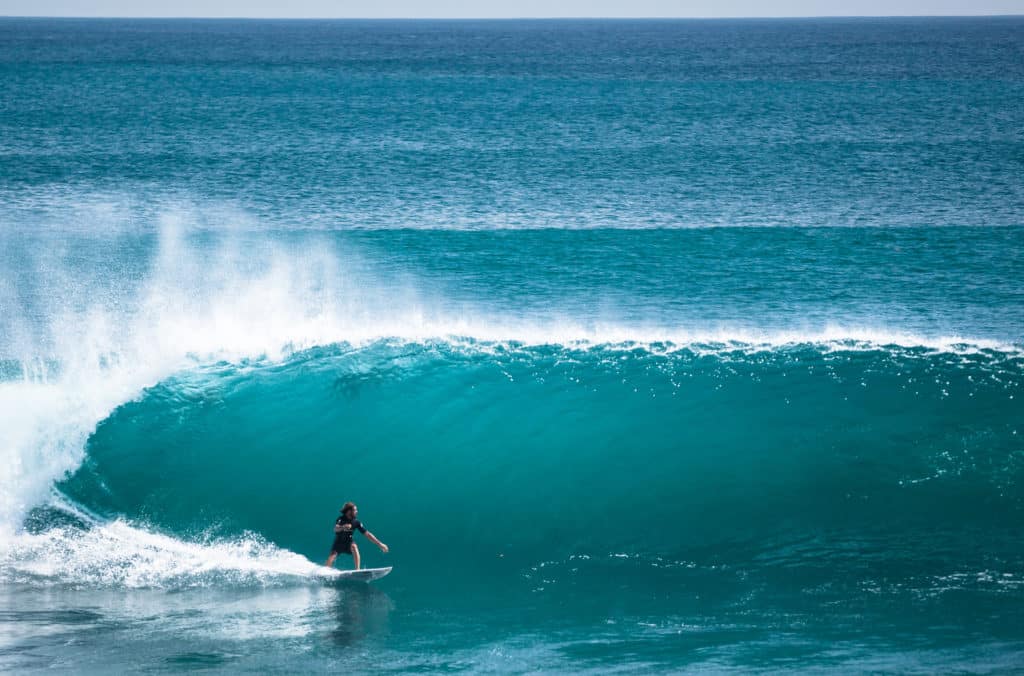 Ein Surfer auf einer Welle in Bali Seminyak