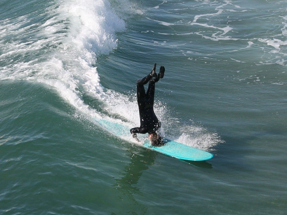 Surfer doing a headstand on their board