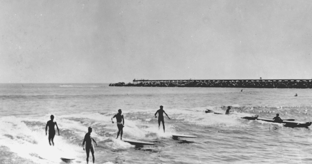 Surfers riding waves in Portugal in the 50s