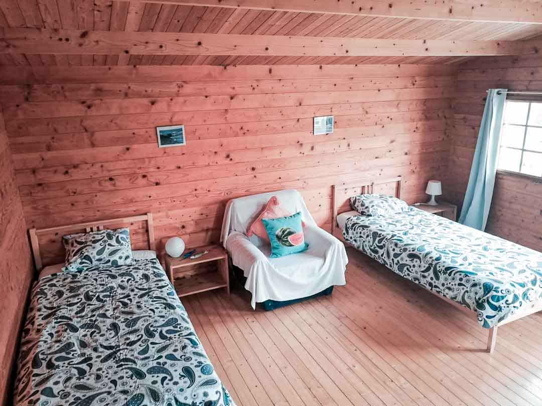 a cabin with 2 single beds and a sofa decorated in a rustic way