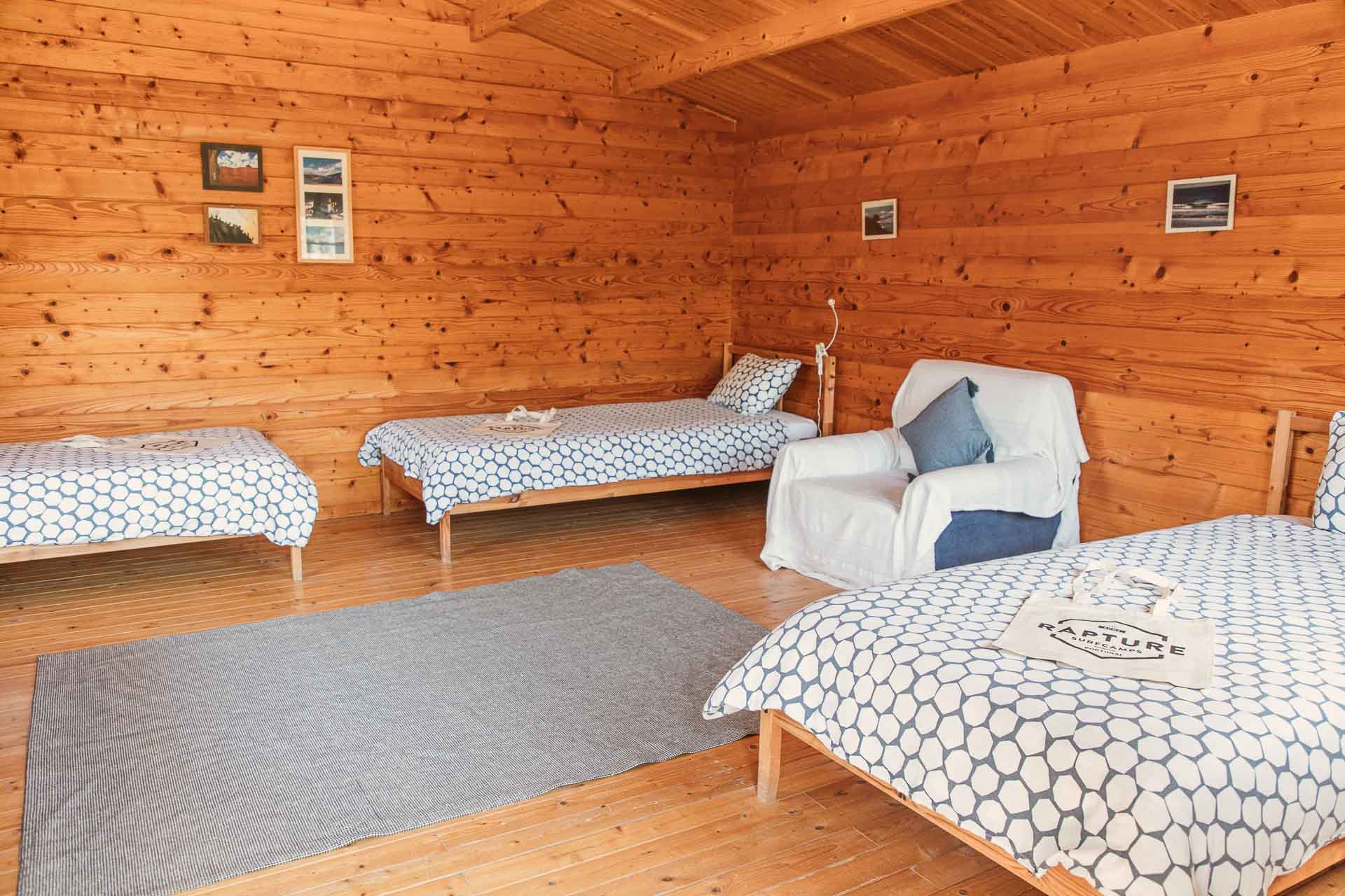 surfcamp shared room 3 single beds and sofa with rustic decor