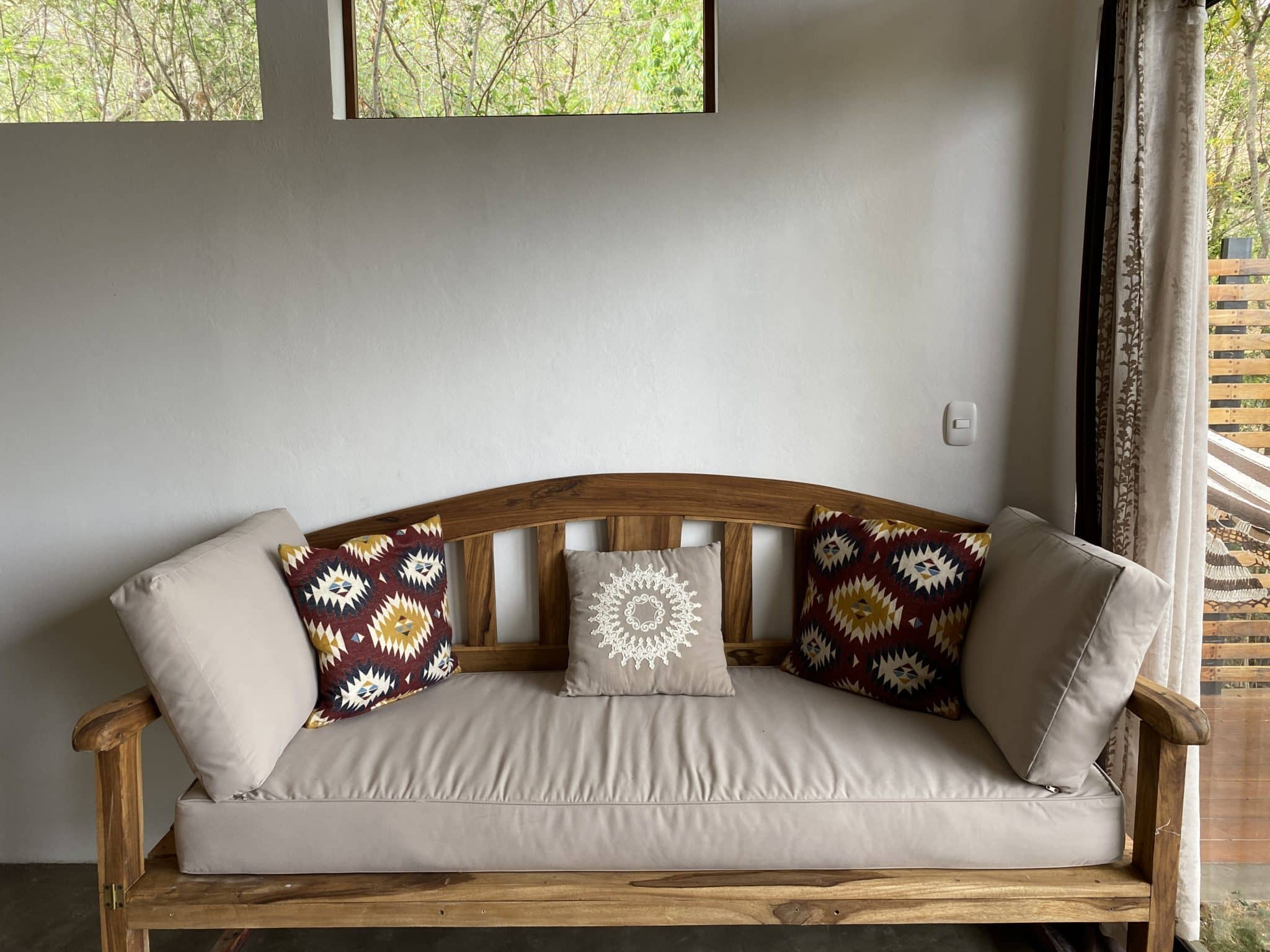 A wooden sette decorated with brown pillows