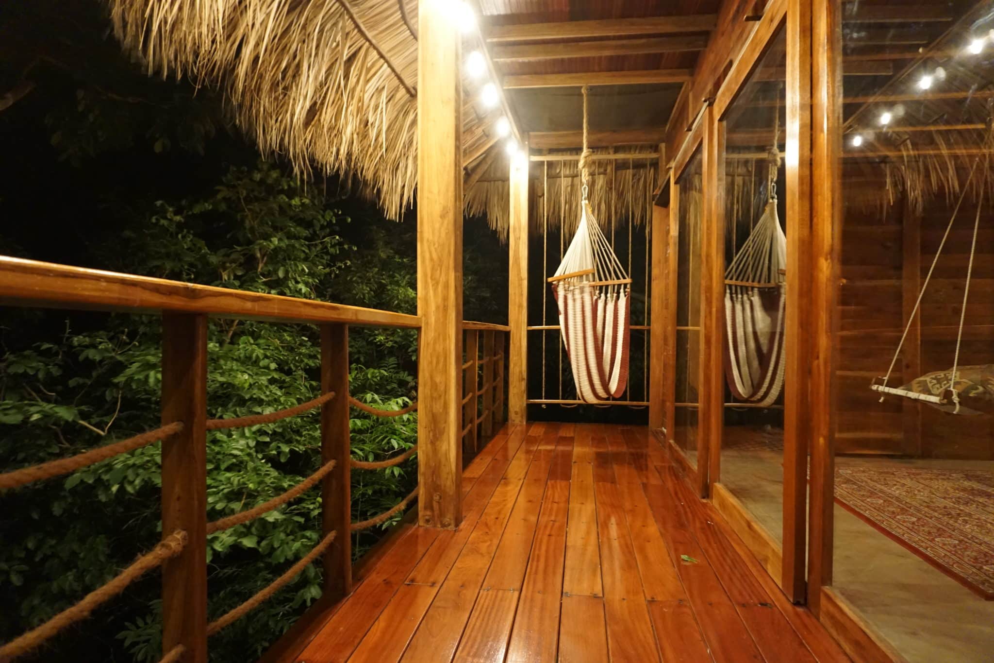 a wooden balcony with hammock net chair