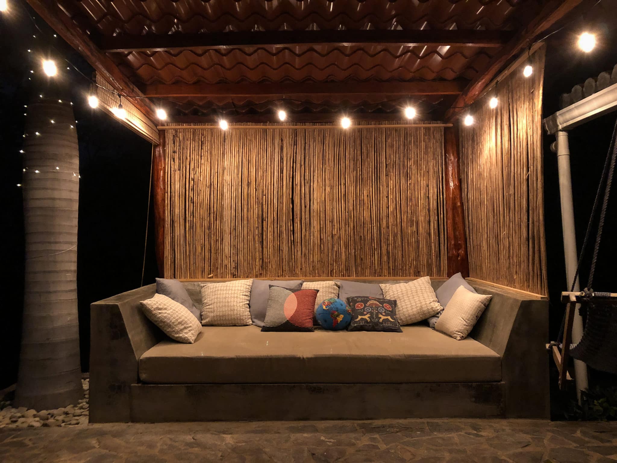 An outside sette with pillows and canopy