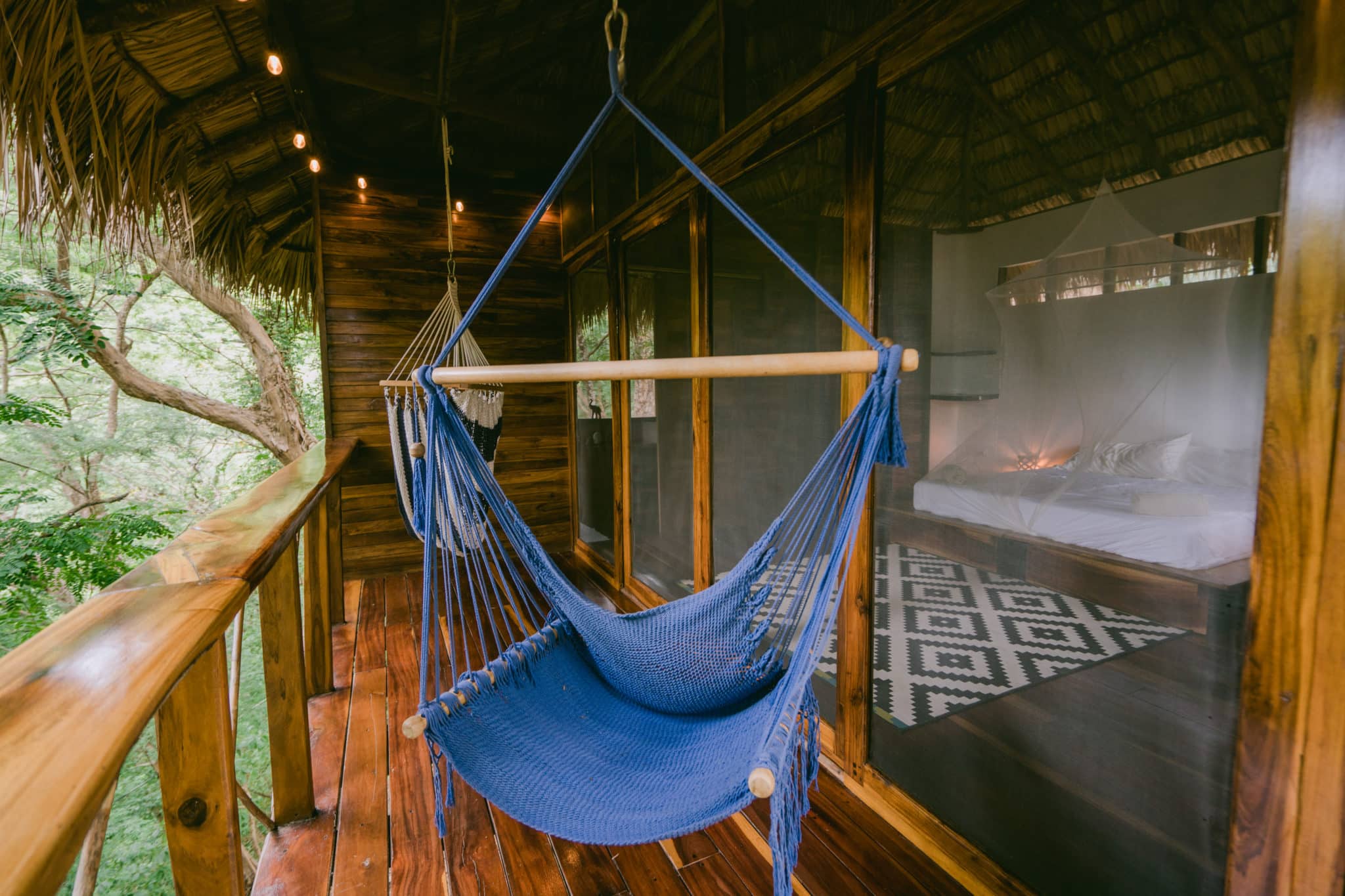 A hammock net chair in a balcony of a spacious an luxurious room
