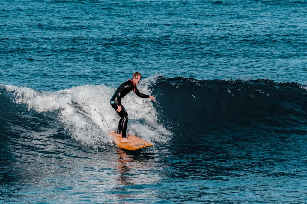 surfer riding waves at rapture surf camp