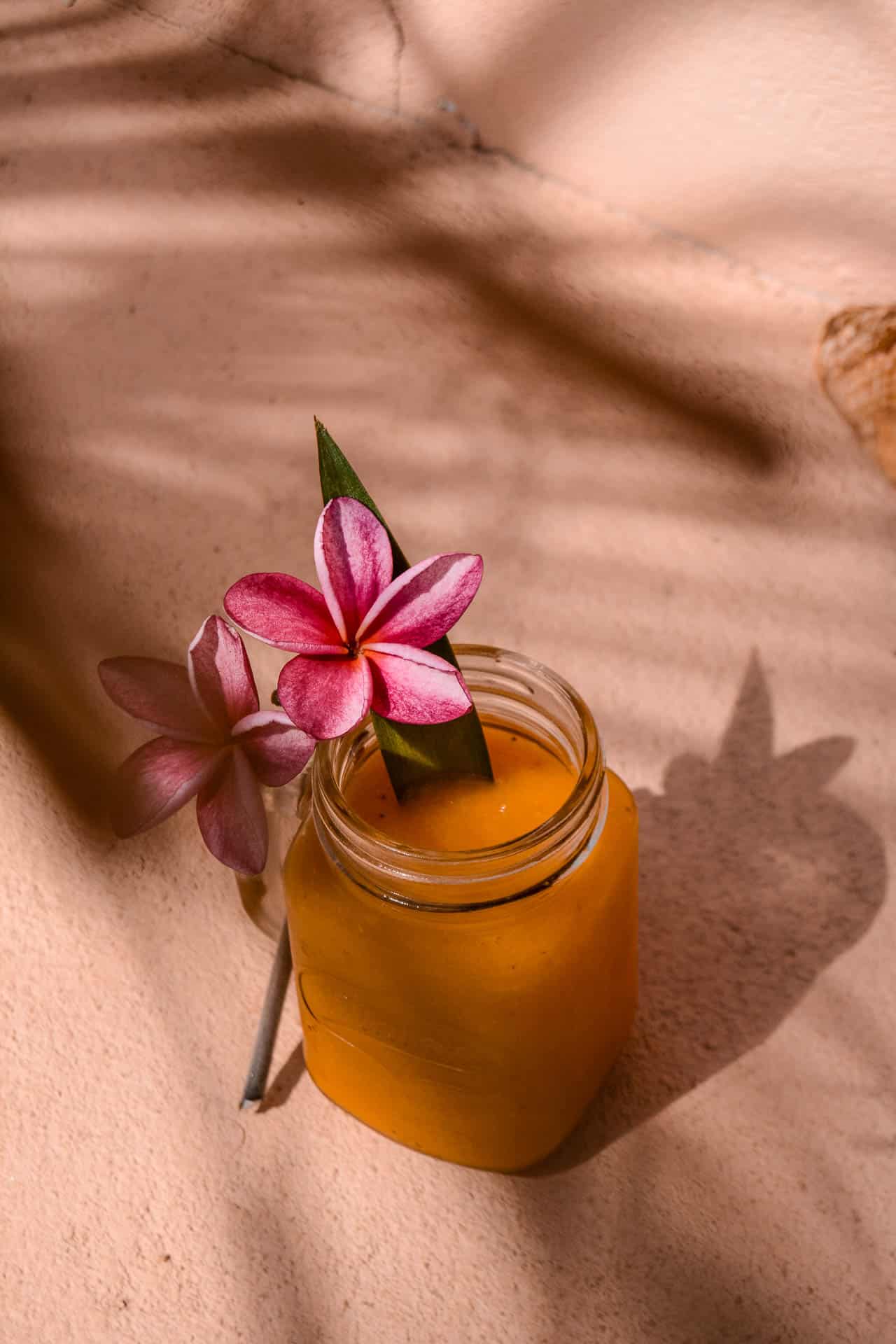 Picture of a orange beverage decorated with tropical flowers