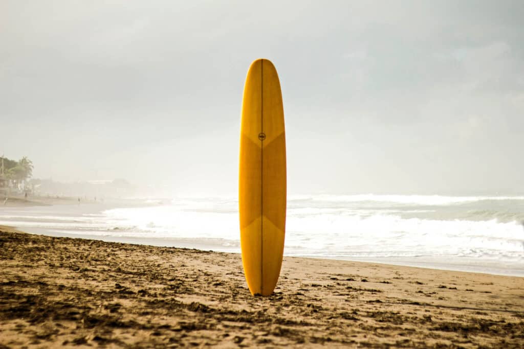 Yellow surfboard on an empty beach