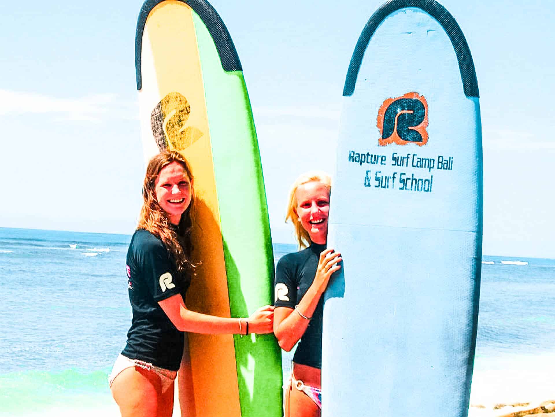 Two girls posing with surfboards_bg