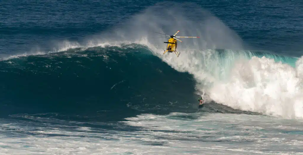 An image of a person surfing one of the highest waves in the world, Maui’s Monster Wave in Hawaii